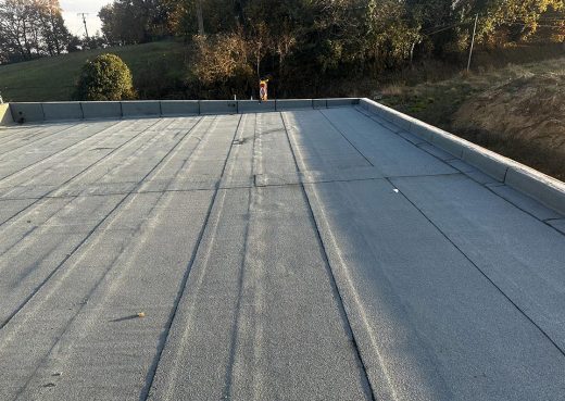 Toit plat gris Le Cannet, étanchéité parfaite par notre patron expert, paysage vert et arbres en fond.